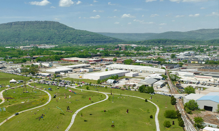 An aerial view of Chattanooga, TN, showing forested mountains and urban development.